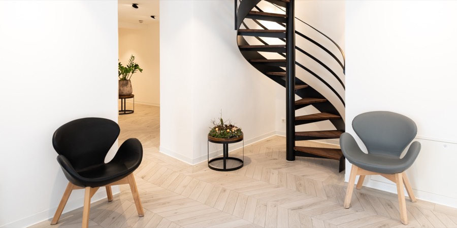 Wartebereich mit Wendeltreppe und Sesseln